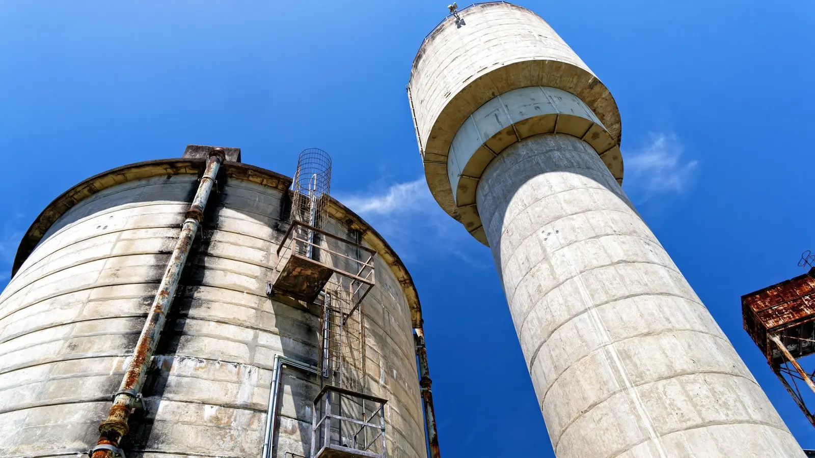 Industrial cement storage silos viewed against a blue sky