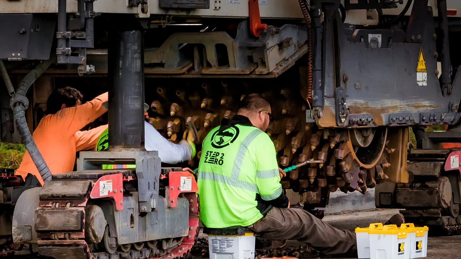 Maintenance technicians inspecting industrial machinery in a workshop